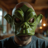 A close-up image of a person wearing a 3D printed stylized half-face mask. The mask features a fantasy goblincore or woodland creature design with wide protruding ears, prominent sculpted brow ridges, and an animalistic snout, covering the upper half of the face while leaving the mouth exposed.