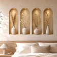 Four tall arched beige wall niches with warm overhead spotlights, each displaying a cream ceramic vase filled with a different dried botanical arrangement in soft neutral tones.