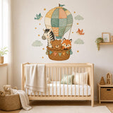 Nursery wall decal with a zebra, sleeping bear and fox riding in a patchwork hot air balloon among clouds and stars.