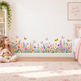 Watercolor flower border wall decal showing mixed wildflowers and butterflies at the bottom of a room wall.