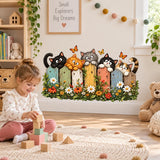 Cat lover wall art featuring five cats peering over a bright wooden fence with daisies and leafy plants.