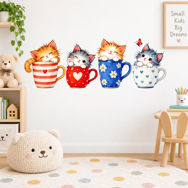 Four watercolor kittens sitting in colorful teacups decorated with hearts, dots and daisies, with a red butterfly above.