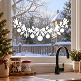 White Christmas window garland with a central bow, long ribbon tails, leafy branches, hanging baubles, stars and snowflakes.