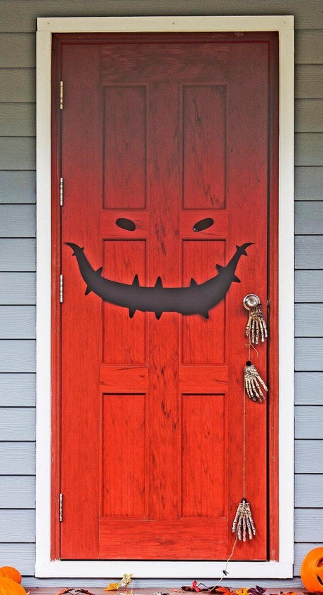 Grinning face vinyl decal displayed on a red door.