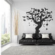 Large tree wall decal in stylish living room with black sofa, adding nature-inspired decor.
