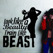 Fitness gym wall decal with motivational quote 'Look like a beauty, train like a beast' and woman lifting weights.