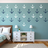Vintage anchor wall decals in navy and white on a teal wall, creating a nautical theme in a bedroom.